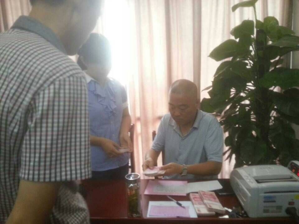 一边在客户排队定肥，一边是红色劲典农化销售团队等记信息