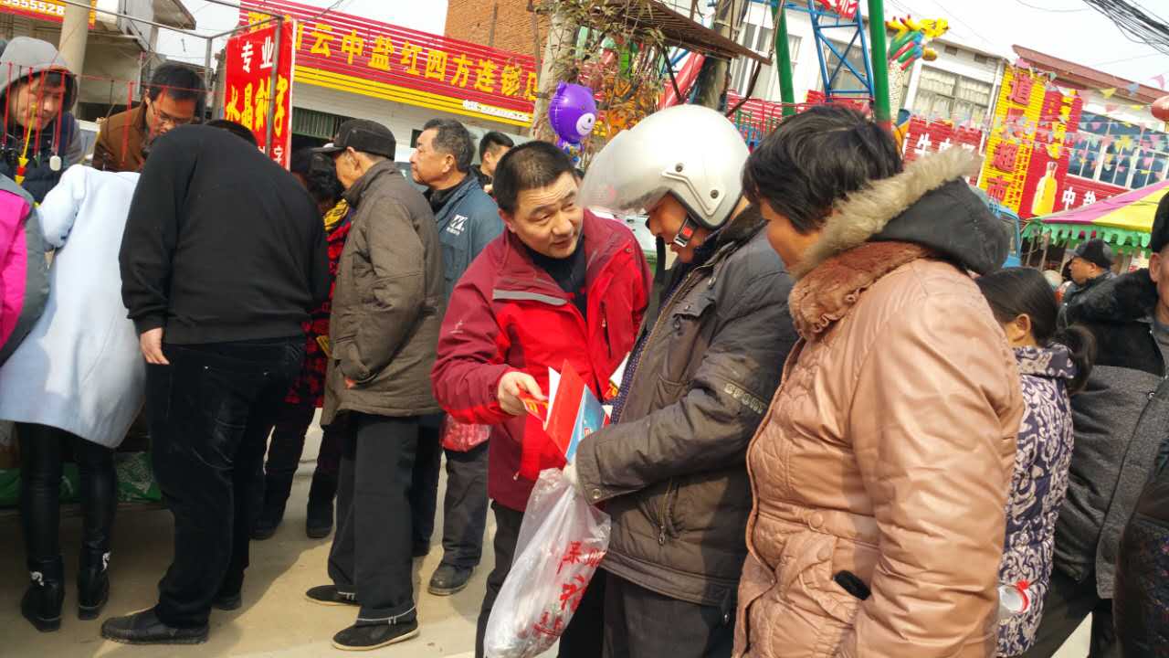 业务经理正在想购肥的老乡介绍红色劲典复合肥产品